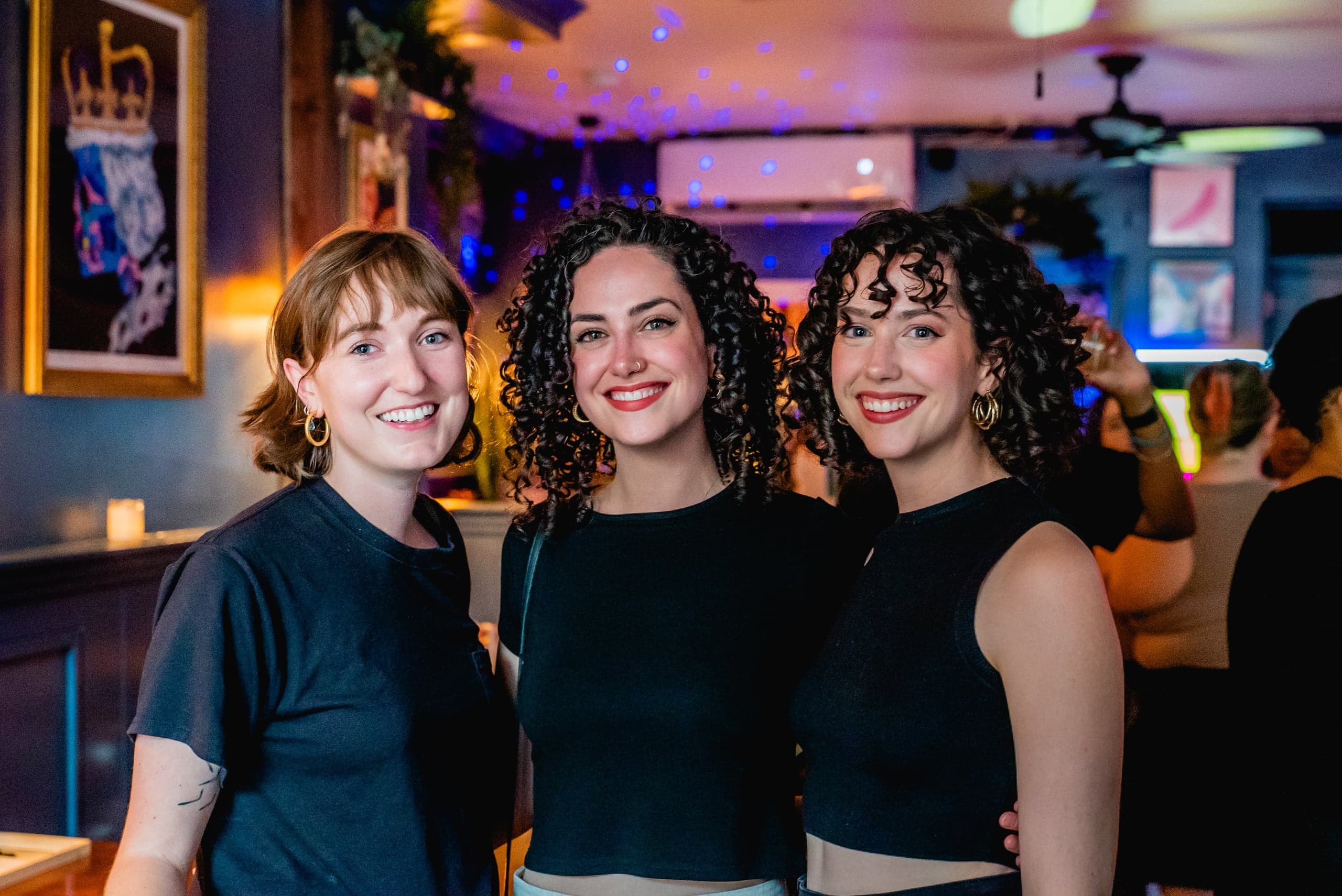 Three guests smiling together at a networking reception