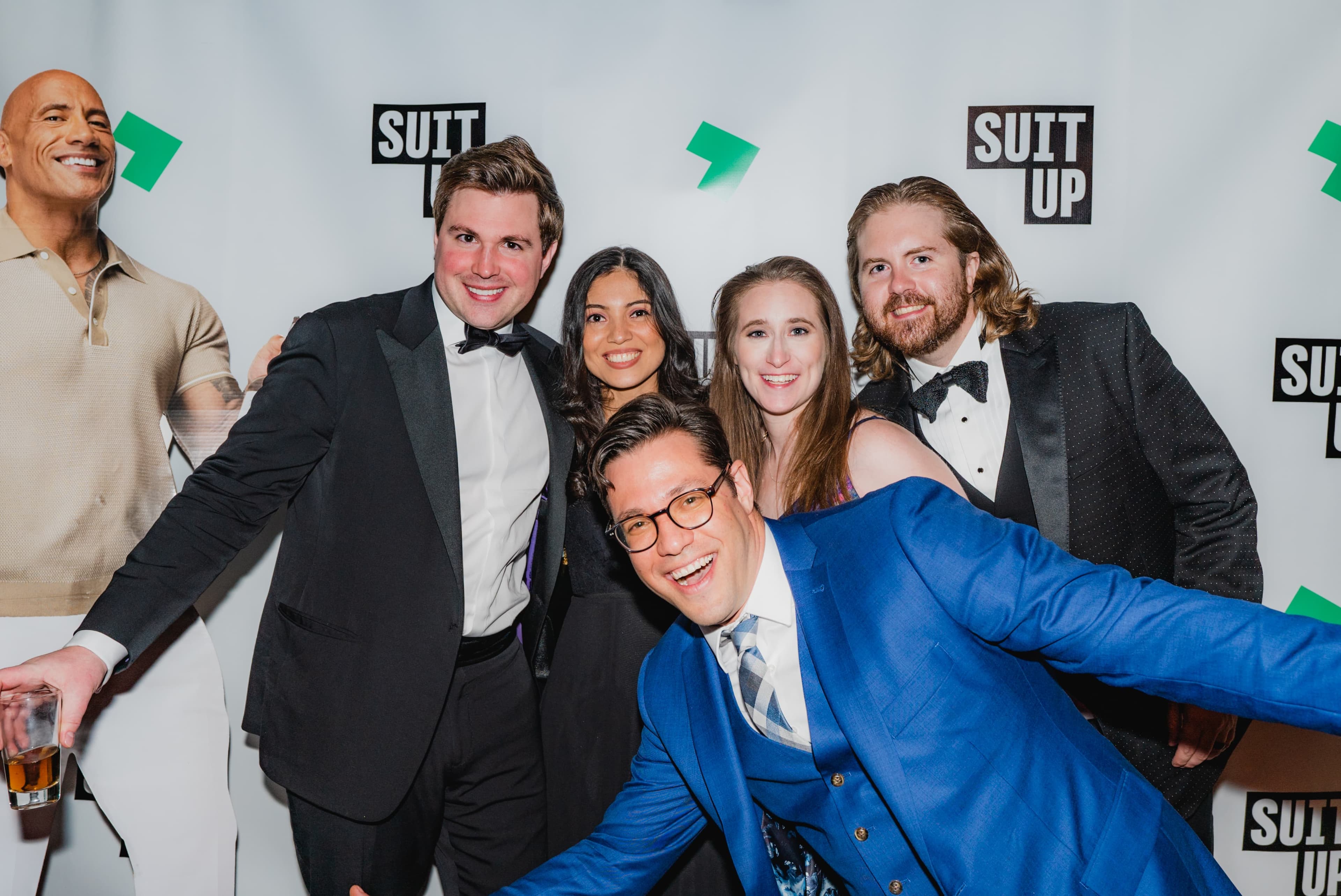 Guests celebrating under stage light at a large gala